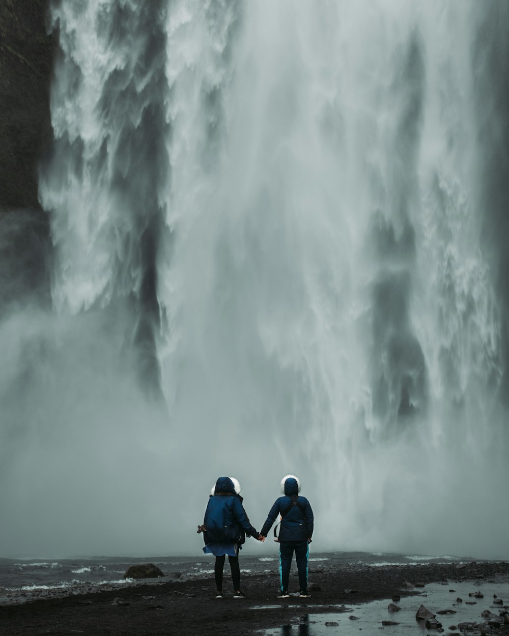two person standing waterfalls