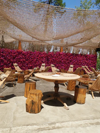 A vibrant outdoor seating area of a Saint Lucia restaurant with colorful tropical flowers surrounding wooden tables.