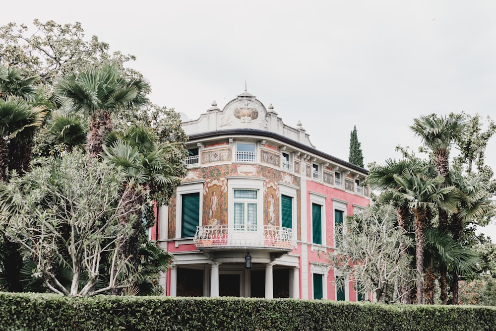 white, beige, and pink building near trees