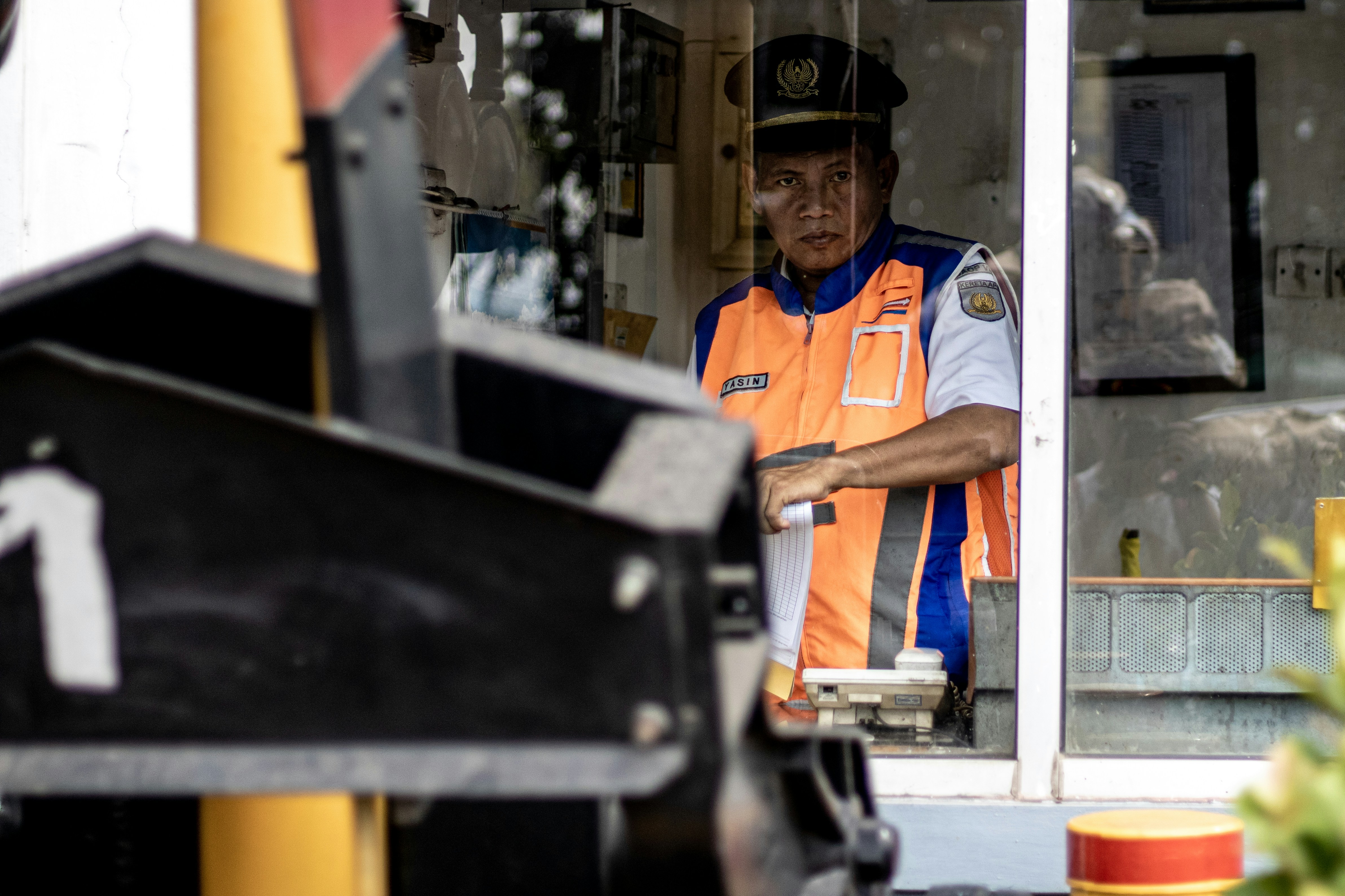 A man behind safety between rail train and road in Jl Dupak Surabaya