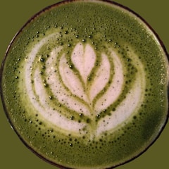 A close-up of a matcha latte with a beautiful latte art design.
