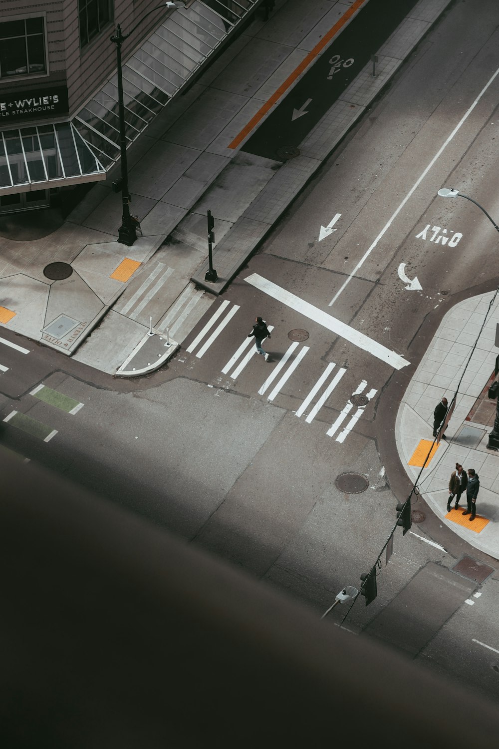 灰色のコンクリート道路に立つ人物のハイアングル写真