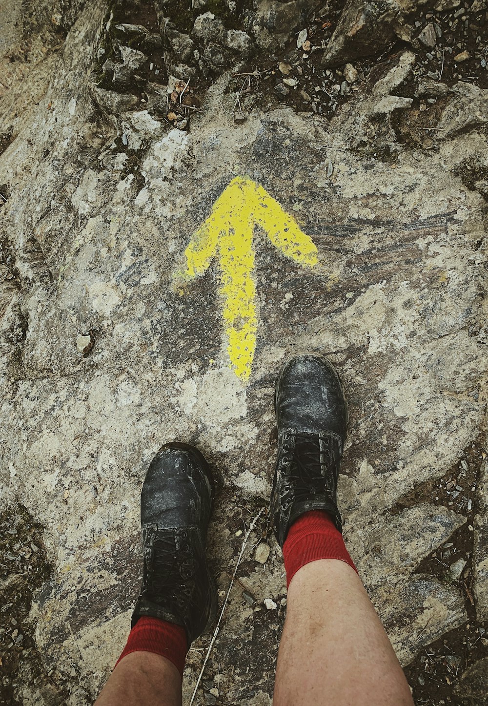 person standing in front of yellow arrow print on floor