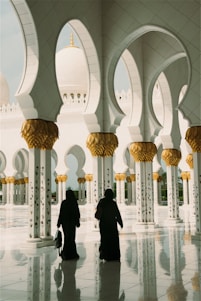 two women standing near white pillars