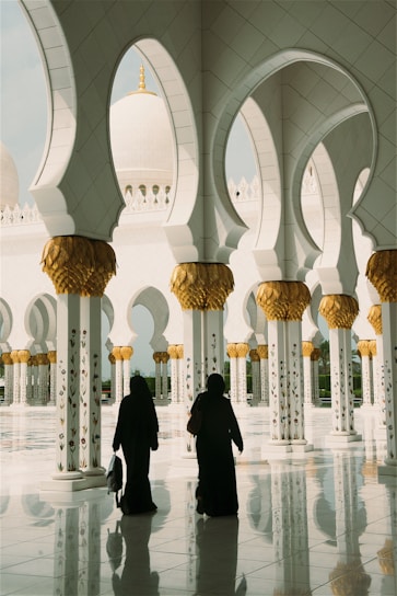 two women standing near white pillars