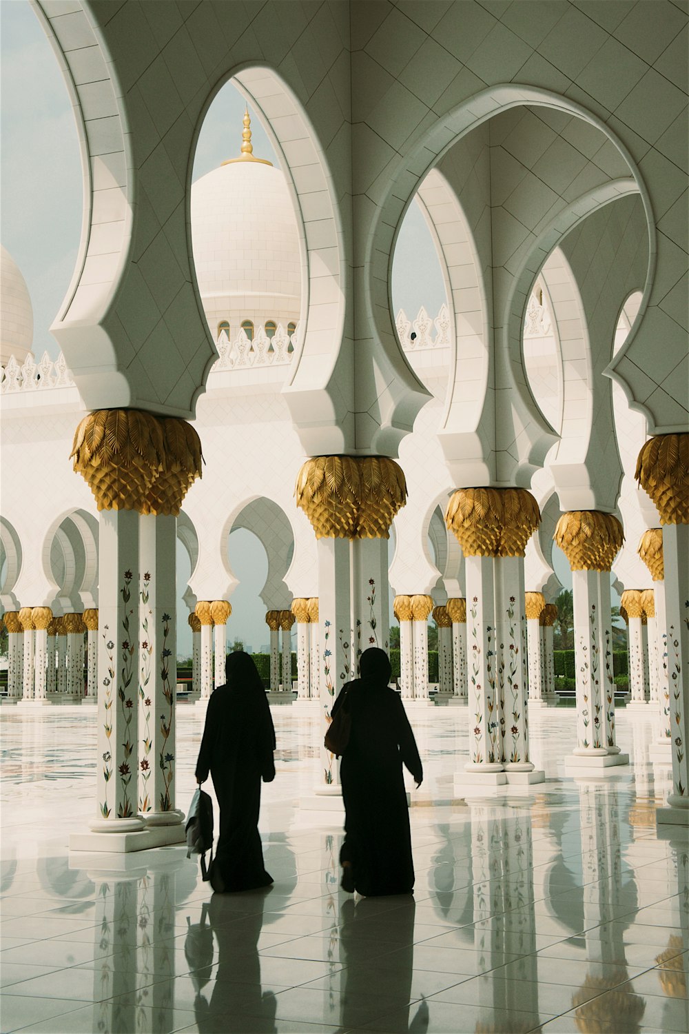 two women standing near white pillars