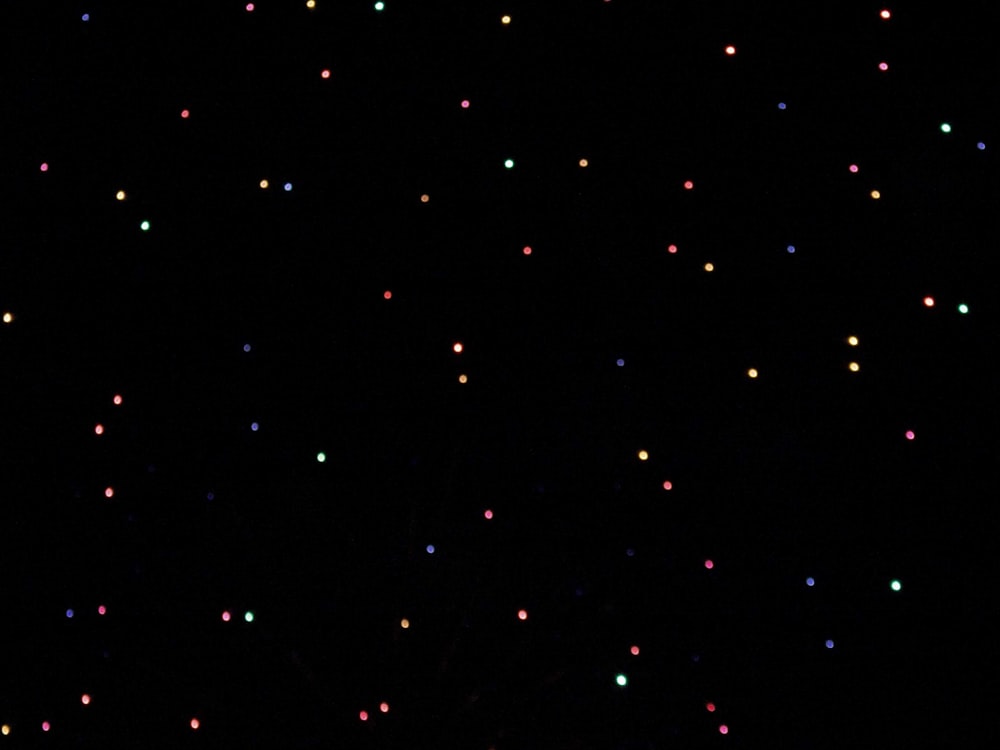 uno sfondo nero con molte luci colorate su di esso