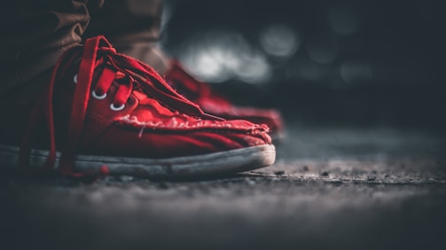 A close-up of worn sneakers on cracked pavement, symbolizing resilience in tough neighborhoods.