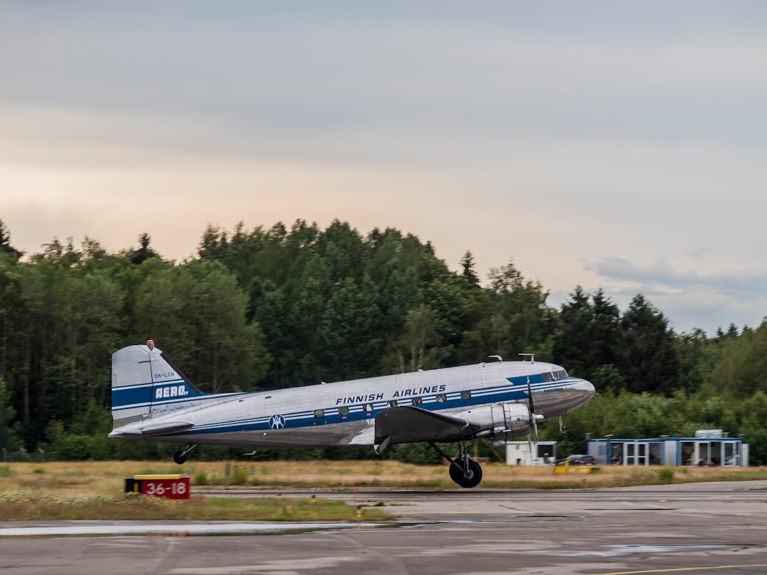 white and blue airplane taking off during daytime