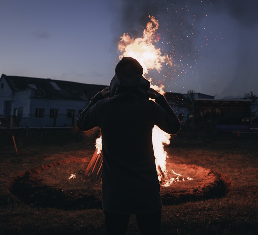 person standing in front of bonfire