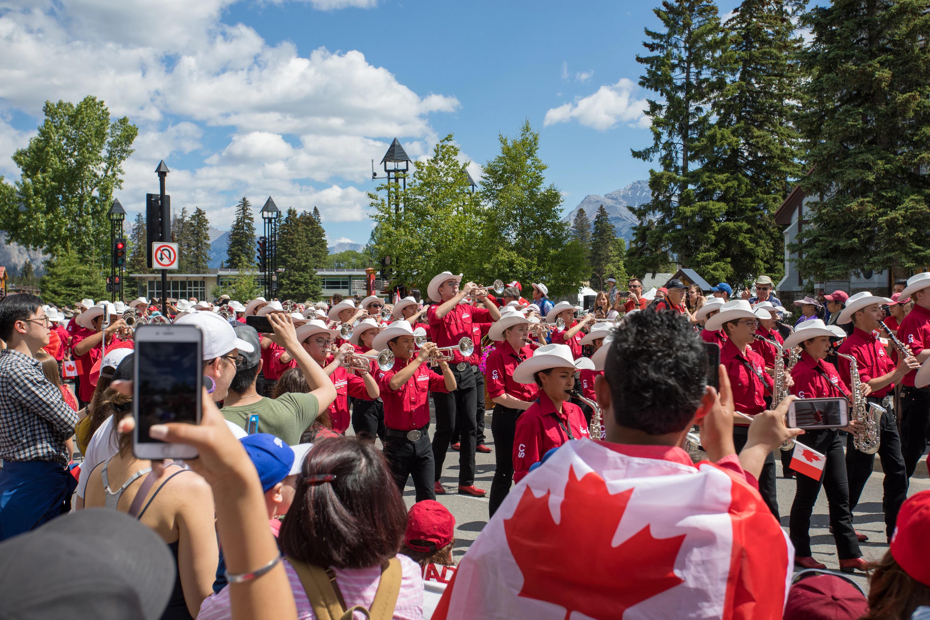 Crowd waving Canadian flags at a Canada Day parade in Banff