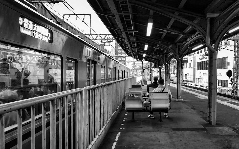 Personas sentadas en una silla cerca del tren