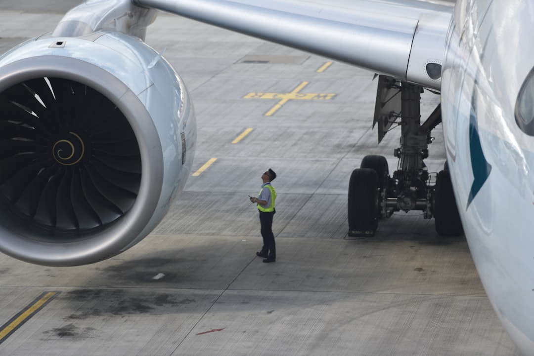 man standing near right airplane wing,