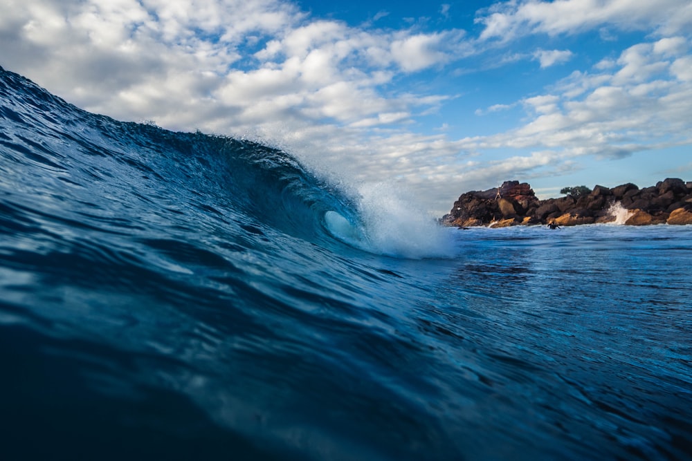 blue sea wave under blue and white skies