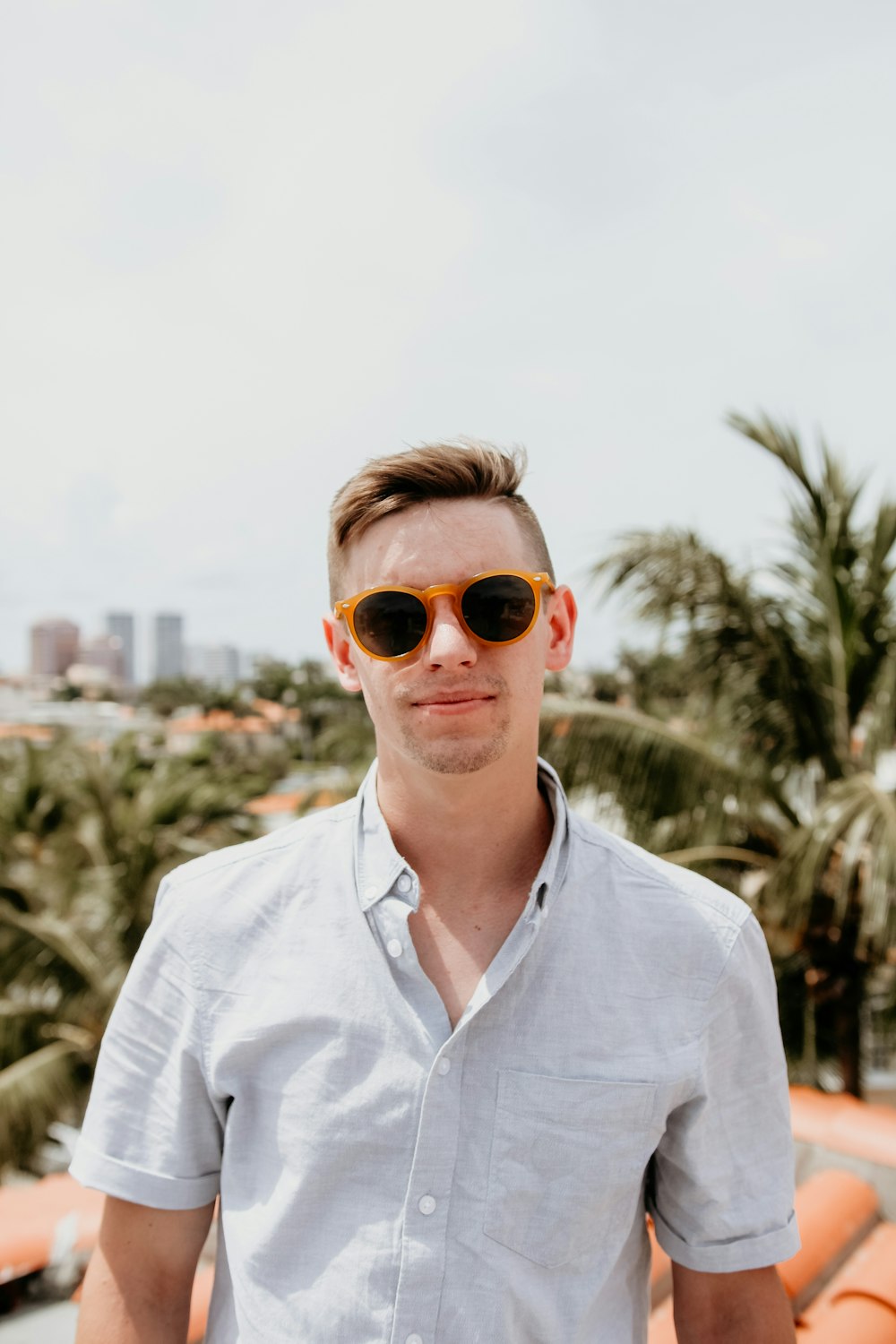 man wearing white dress shirt across green palm trees