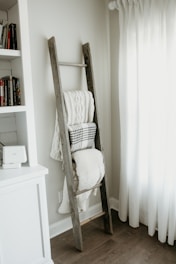 textiles hanging on gray wooden ladder