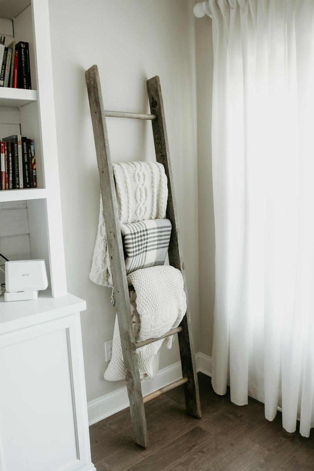 textiles hanging on gray wooden ladder