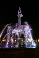 Elegant fountain lit by subtle, shimmering water feature lights reflecting on ripples.