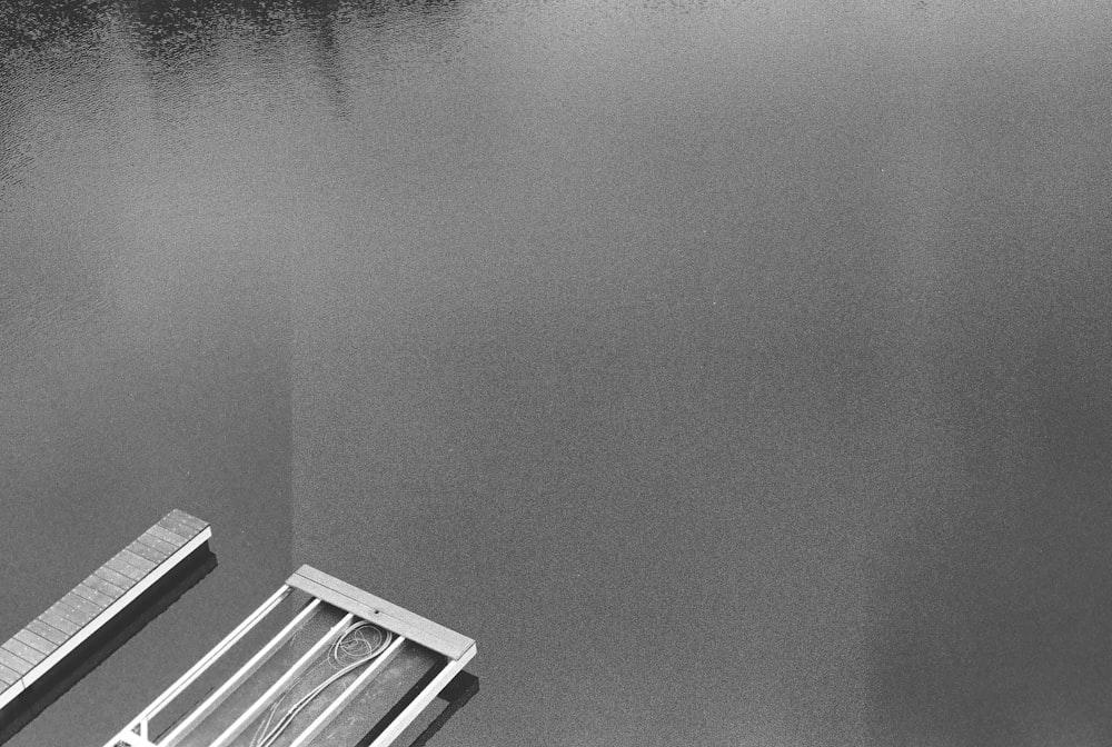 a black and white photo of a bench and a body of water