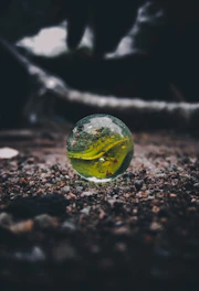 A small marble rolling on a smooth black surface, capturing the momentum concept.