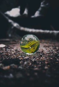 A small marble rolling on a smooth black surface, capturing the momentum concept.
