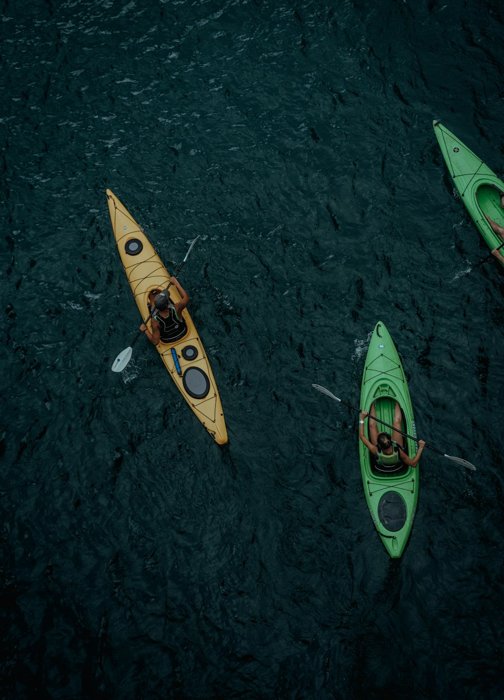 Tres personas navegando en kayak en un cuerpo de agua
