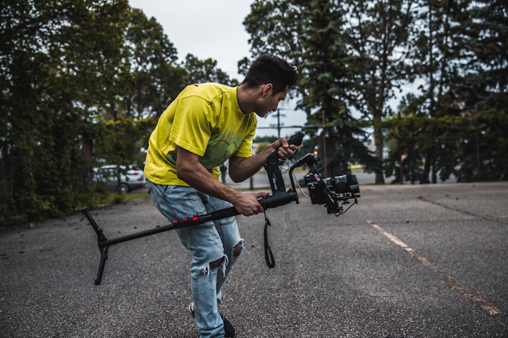 man wearing yellow shirt holding camera