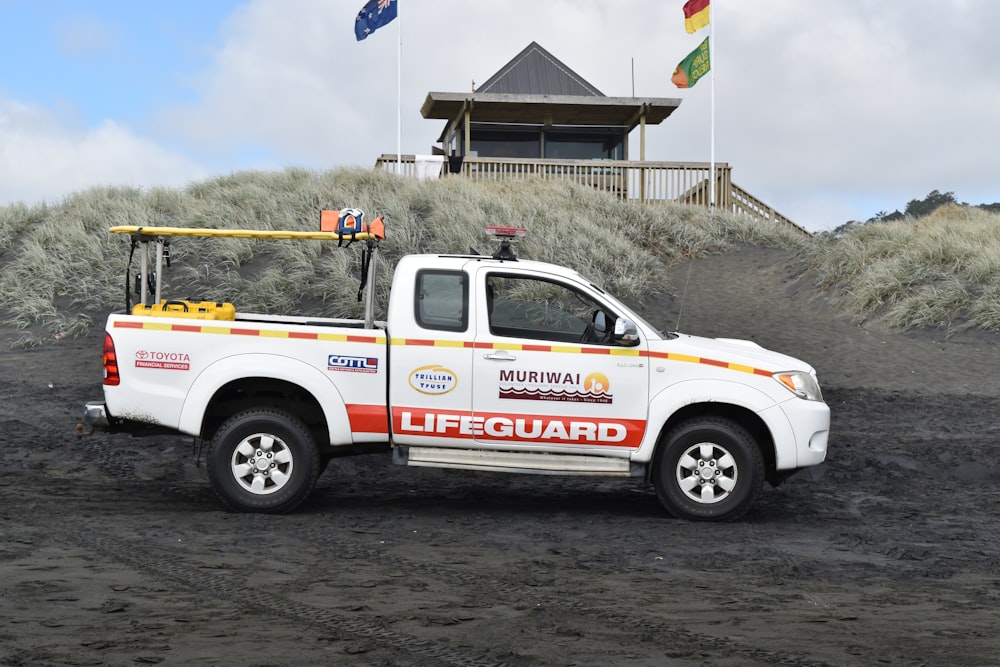 white pickup truck parked on sand