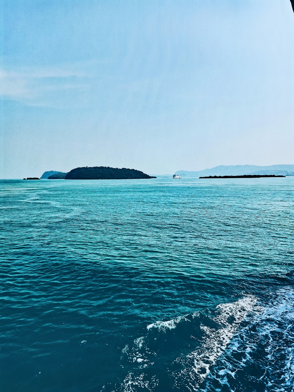 silhouette of island on body of water during daytime