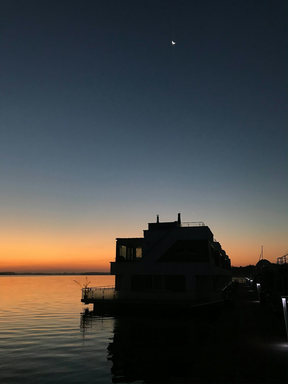 a boat sitting in the water at sunset