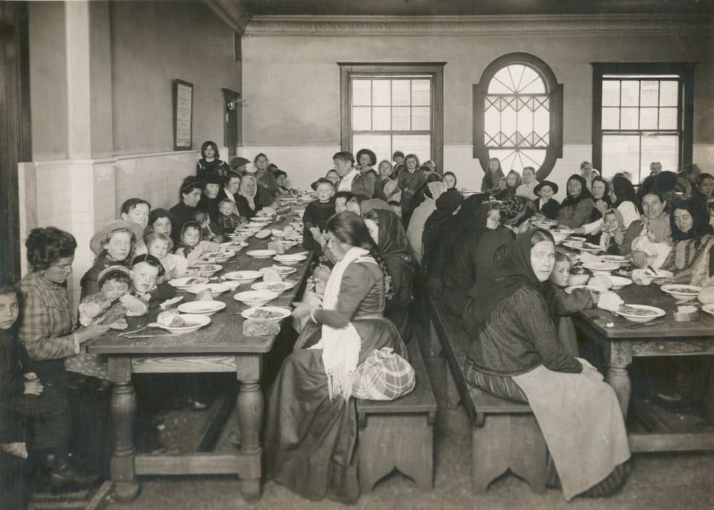 gray scale photo of people dining