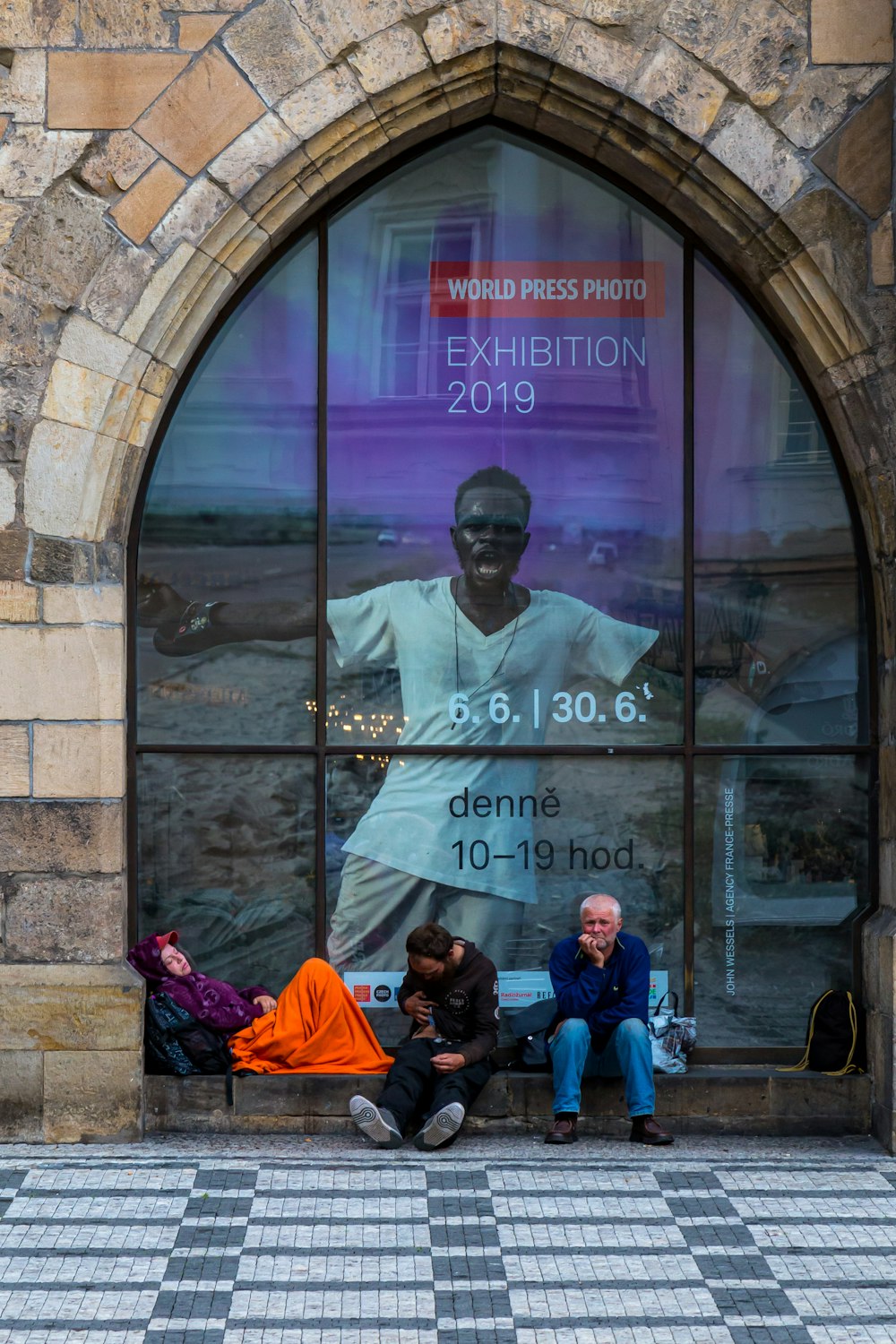 persone sedute vicino al muro del negozio