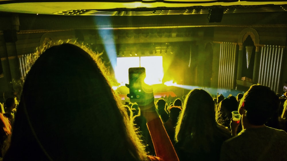 mulher segurando o telefone virado para o palco