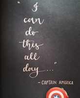 A motivational quote in elegant cursive handwriting on a dark background reads 'I can do this all day...' attributed to Captain America. Below the text, a small depiction of Captain America's shield is visible, emphasizing a theme of strength and perseverance.
