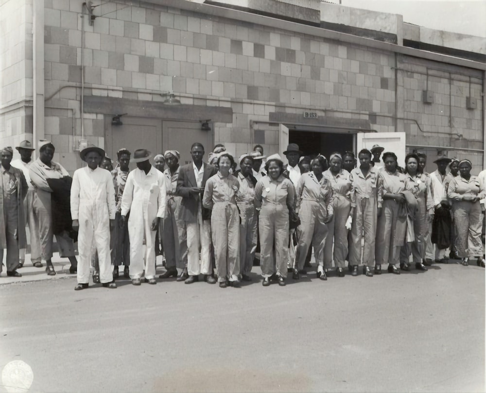 grayscale photo of crowd outside building