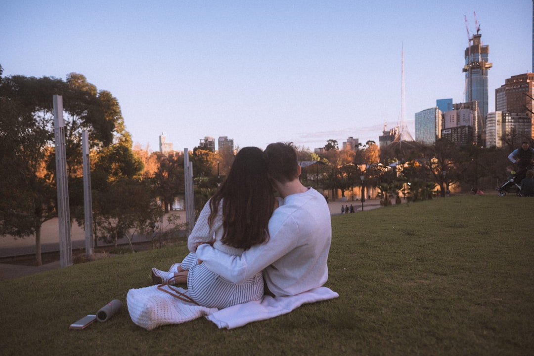 couple seated on hill during daytime