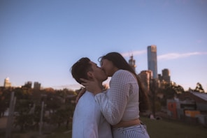 couple kissing under blue sky during daytime