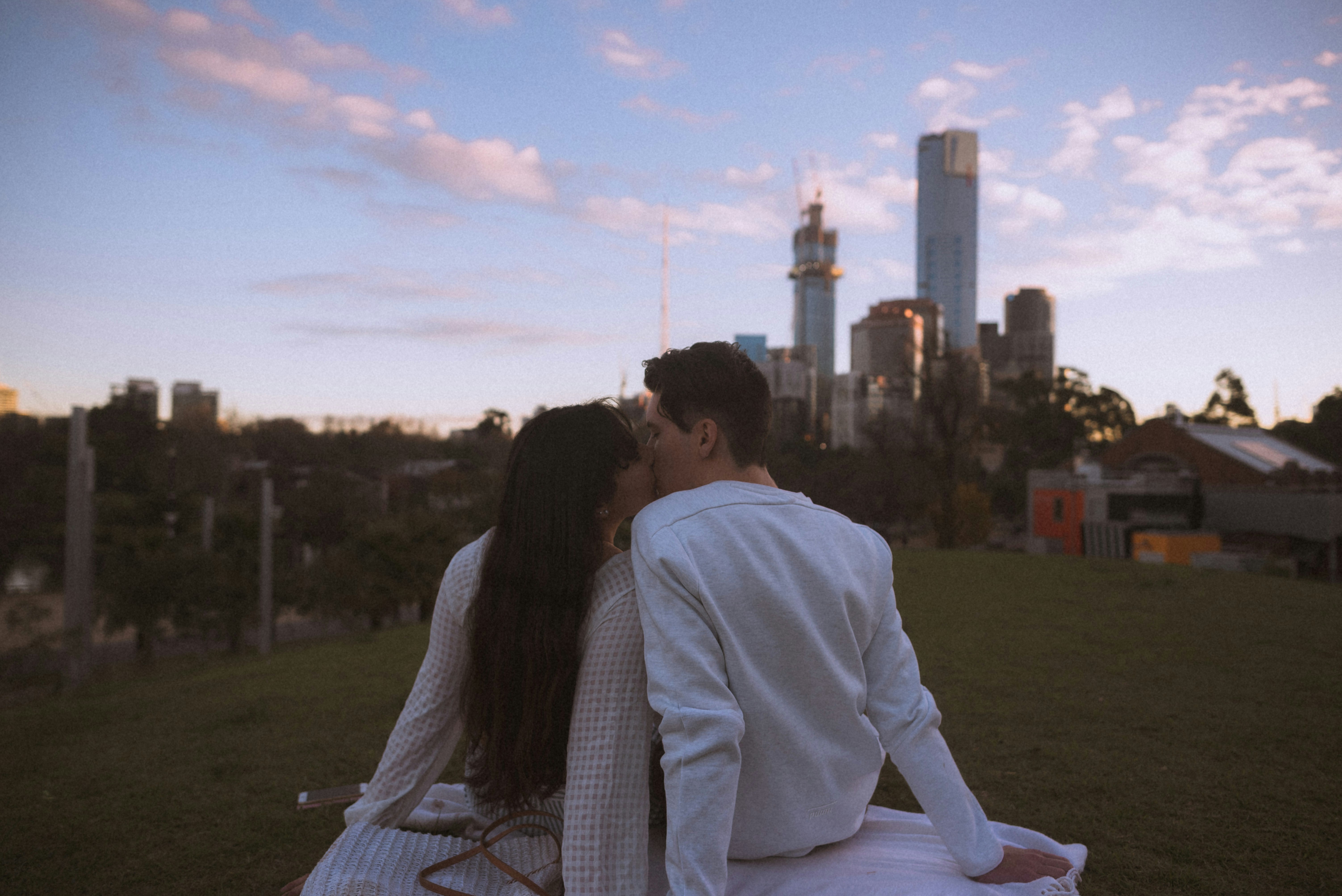 couple sitting on white textile during daytime