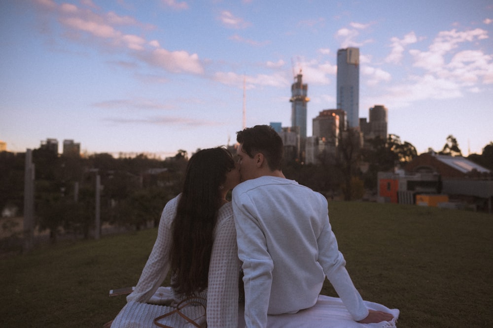 couple sitting on white textile during daytime