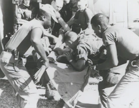A warm photo of a caring first responder assisting a patient with an ambulance in the background.