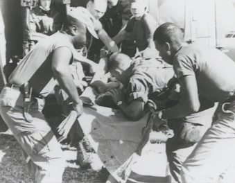 A sturdy, foldable medical stretcher with blue padding ready for patient transport.