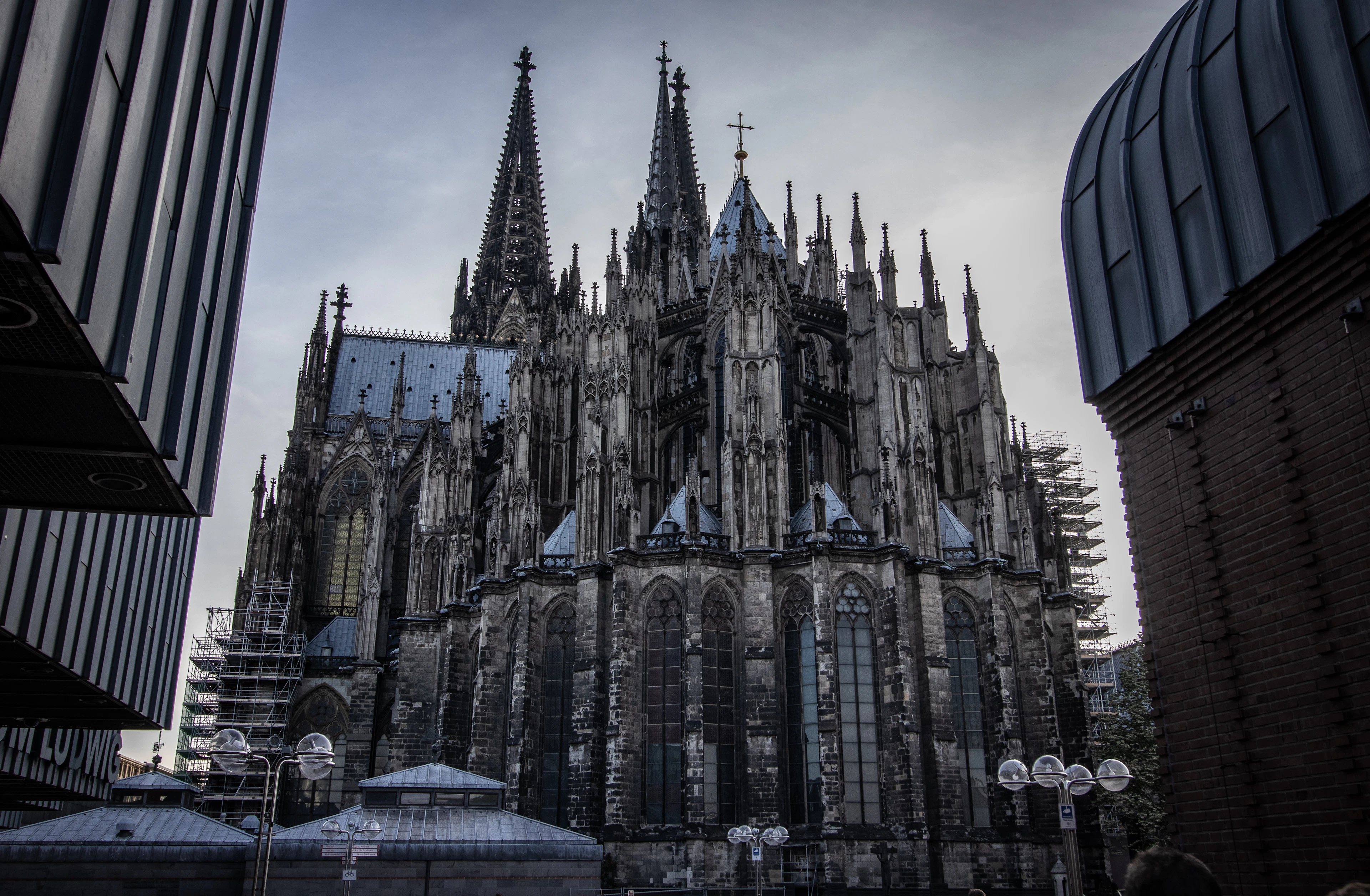 The twin Gothic spires of Cologne Cathedral towering over the surrounding city under a moody sky