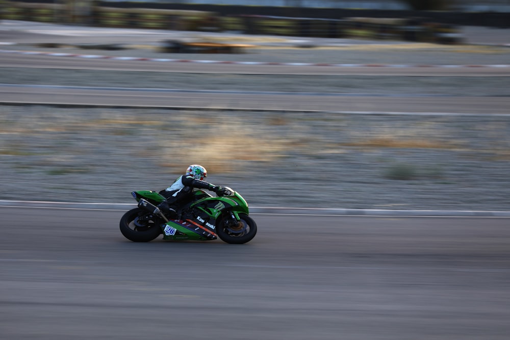 person riding green and black sportsbike
