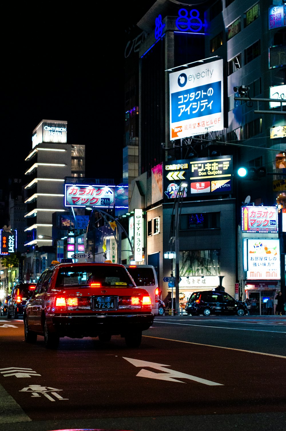 red vehicle in front of the road during nighttime