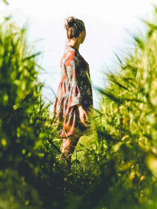 A vibrant photo of a model wearing a breezy summer dress in a sunlit meadow, embodying effortless style.