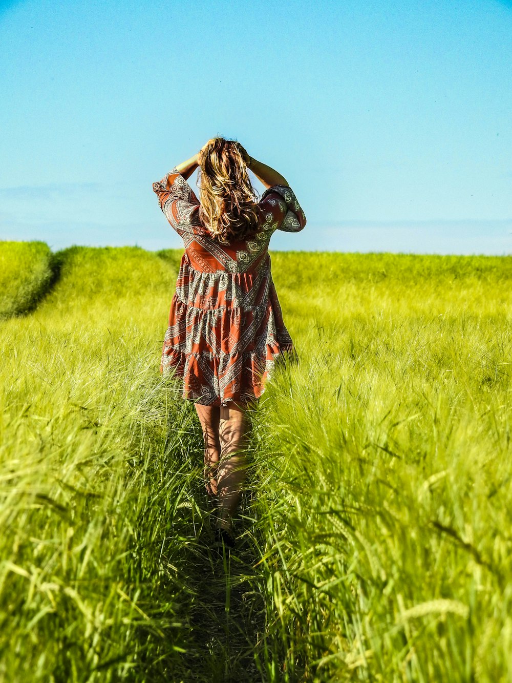woman standing between green grass during daytime