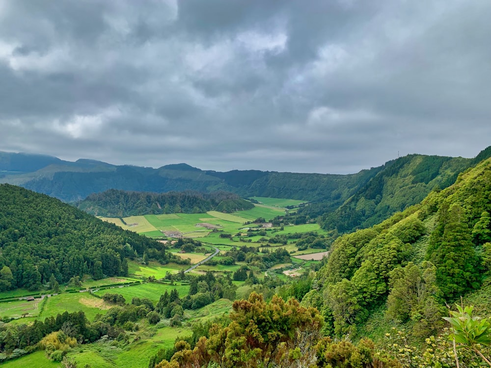 green grass mountain under cloudy sky during daytime