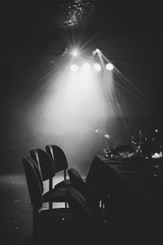 grayscale photography of chairs and table near lights