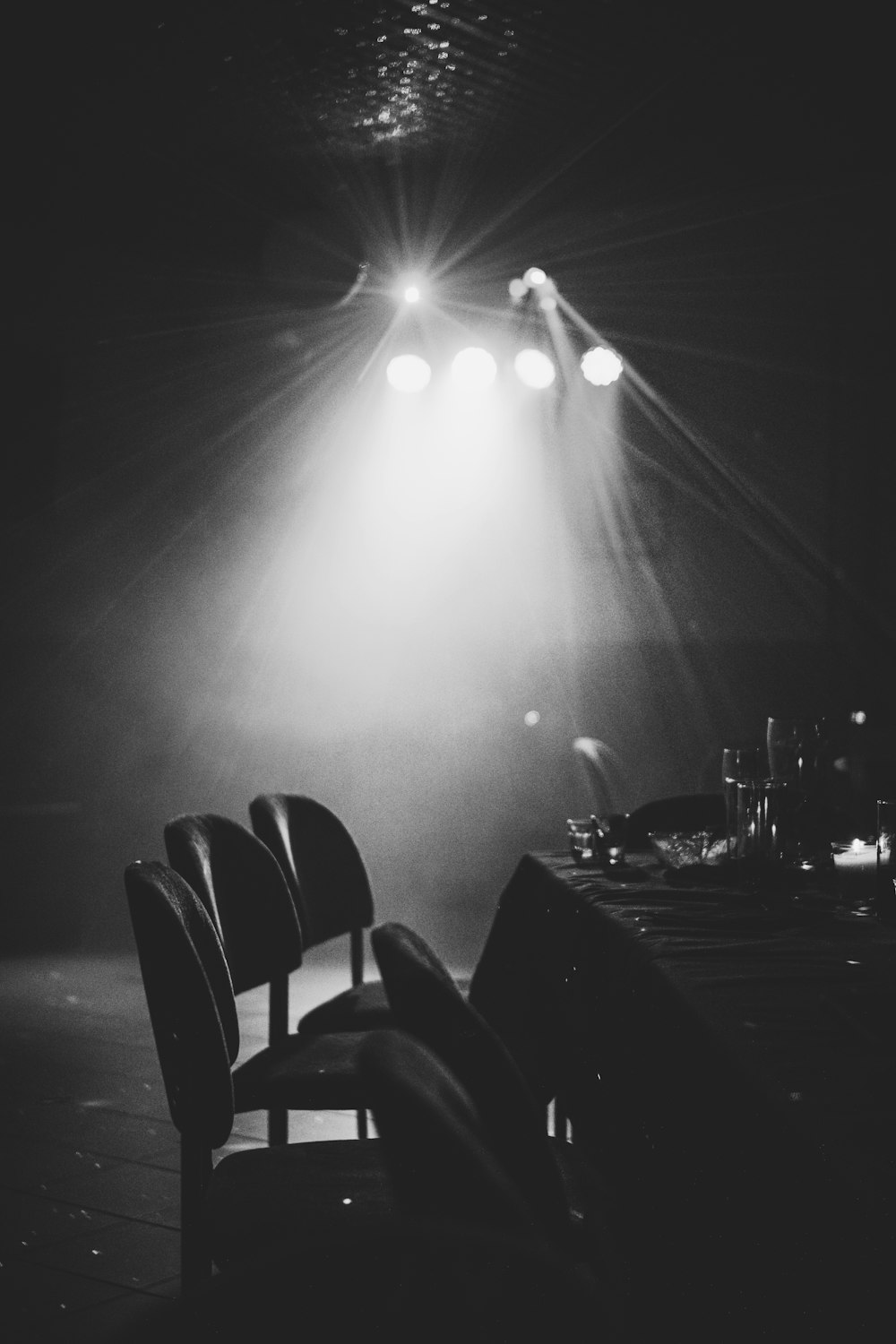 grayscale photography of chairs and table near lights