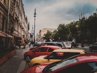 A busy street with various vehicles parked, showcasing different types of cars.